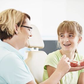 Jugendliche mit Zahnspange erhält Beratung zur Kieferorthopädie beim Zahnarzt.